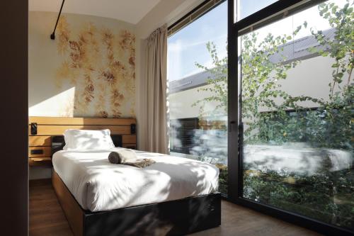A bed or beds in a room at VERSOVERDE HOTEL Alzaia Naviglio Grande