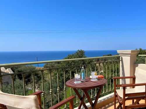 a table on a balcony with a view of the ocean at Villa Marianna in Lourdhata