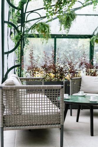 a wicker chair and a table in a greenhouse at Palacio de Aviles Affiliated By Melia in Avilés