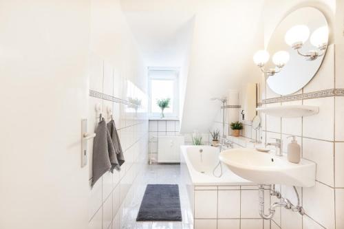 a white bathroom with a sink and a mirror at CenterApartment, WIFI, SmartTV, full Kitchen, Netflix, Pottbude in Essen in Essen