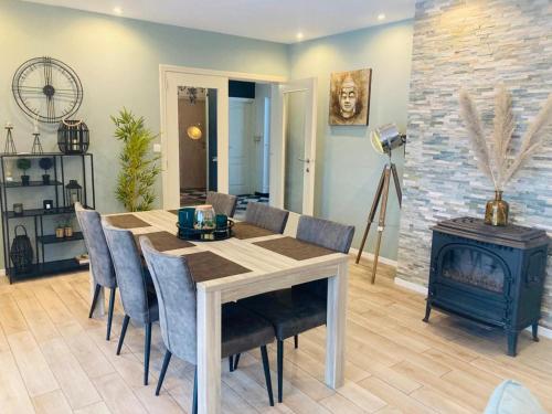 a dining room with a table and chairs and a fireplace at Maison de vacances privative à louer in Aywaille