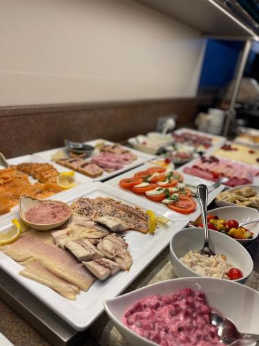 a buffet with many different types of food on trays at BUDE16 Boardinghouse in Norden