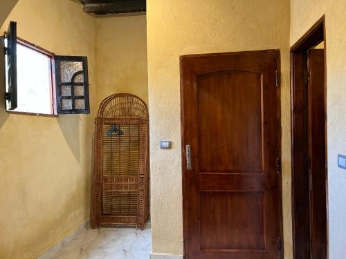 a room with a wooden door and a window at Zad El Mosafer Guest House in Tunis