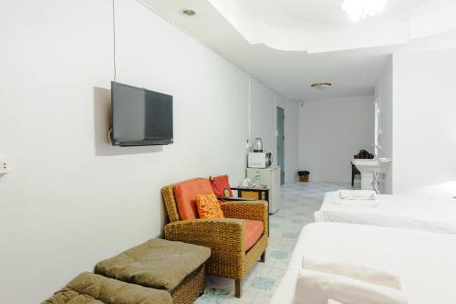 a room with two chairs and a tv on the wall at High5 Guesthouse in Pattaya