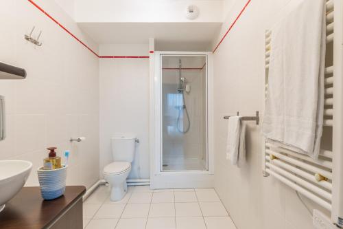a bathroom with a shower and a toilet and a sink at Zenitude Hôtel-Résidences Magny-les-Hameaux in Magny-les-Hameaux