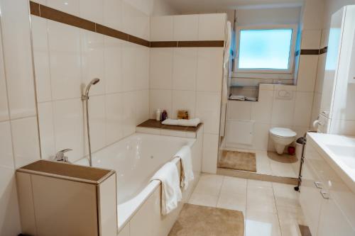 een witte badkamer met een bad en een toilet bij -City-Apartment, Buchs SG, Skie, Wanderroute, WiFi- in Buchs