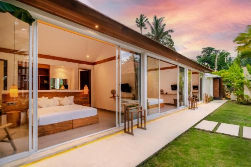 1 dormitorio en una villa con paredes de cristal en Villa Noemie by BaliSuperHost en Ubud