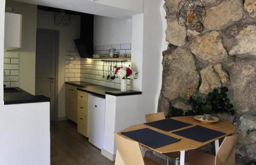 eine Küche mit einem Tisch und einer Steinmauer in der Unterkunft Sigulda City Center Holiday House in Sigulda