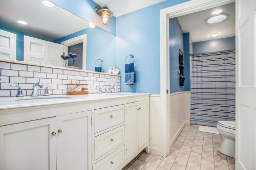 baño con paredes azules, lavabo y aseo en Michigan Shores, en New Buffalo