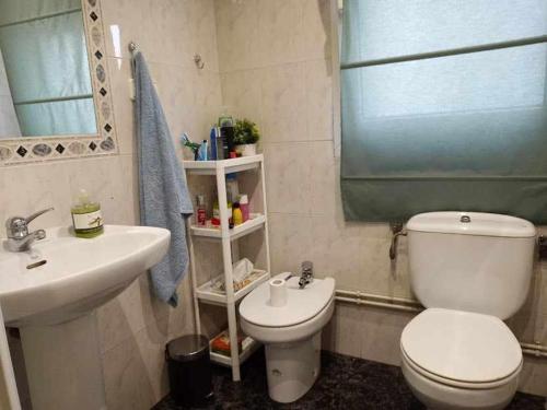 La salle de bains est pourvue de toilettes blanches et d'un lavabo. dans l'établissement FlipHouse Rooms Pensión, à Bilbao