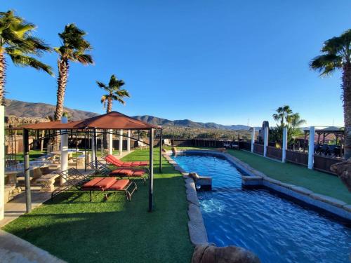 a pool with chairs and palm trees in a resort at Finca Selah in Ensenada
