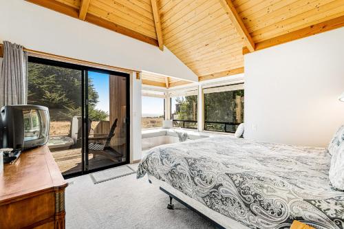 une chambre avec un lit, une télévision et des fenêtres dans l'établissement Urban Escape, à Sea Ranch