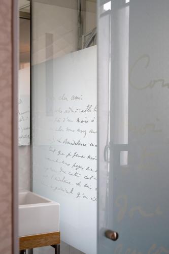 a bathroom with a writing on the wall next to a sink at Hotel Litteraire Le Swann, BW Premier Collection in Paris