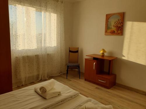 - une chambre avec un lit, un bureau et une fenêtre dans l'établissement Apartamente la rezidenta noua ideale vacanze job etc, à Chişoda