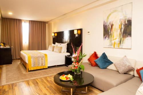 um quarto de hotel com uma cama e um sofá em Hôtel du Golf Mohammedia em Mohammedia