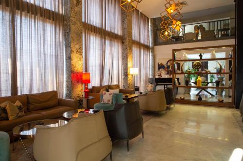 a living room with couches and tables and a mirror at Hôtel du Golf Mohammedia in Mohammedia