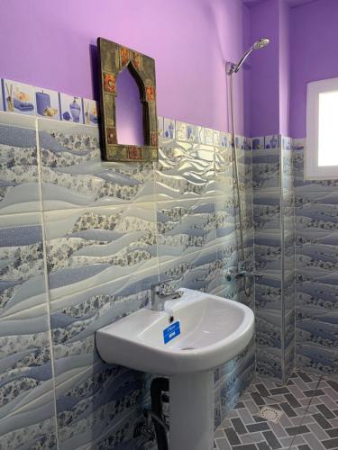 a bathroom with a sink and a mirror at Beach House in Asilah