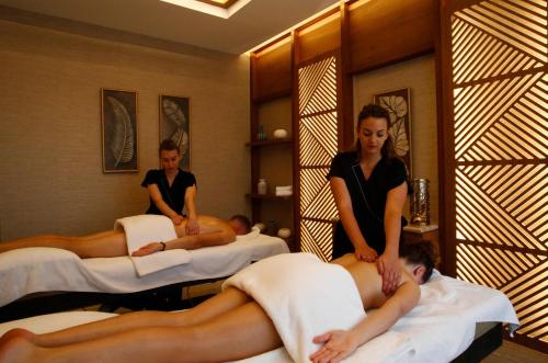 a group of people sitting in beds in a room at Hotel Corsica & Spa Serena in Calvi