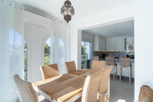 una sala da pranzo con tavolo e sedie in legno di Villa Sandra Luxury Suite a Nerja