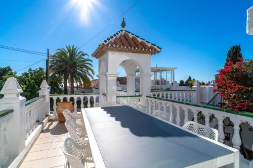 una cerca blanca con un cenador en ella en Villa Sandra Luxury Suite, en Nerja