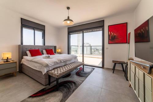 a bedroom with a bed with red pillows on it at Bautiful Penthouse 4Bed with Jacuzzi sea view in Tel Aviv