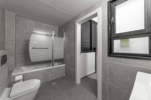 a bathroom with a toilet and a window at Bautiful Penthouse 4Bed with Jacuzzi sea view in Tel Aviv