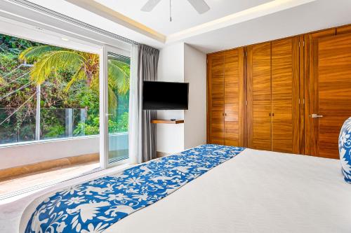 um quarto com uma cama e uma grande janela em Blue Horizon 801 em Puerto Vallarta