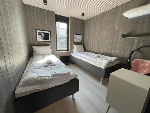 two beds in a room with two beds sidx sidx sidx sidx at Rorbuleilighet Lysøysundet 1G in Henningsvær