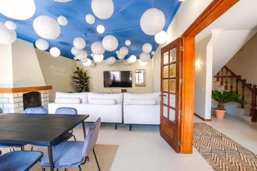 Wohnzimmer mit blauer Decke, Tisch und Stühlen in der Unterkunft Portugal Active Cabedelo Beach Lodge - Heated Pool in Viana do Castelo