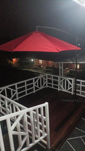 un parapluie rouge au-dessus d'une clôture blanche dans l'établissement Vila Dechalasya, à Mojokerto