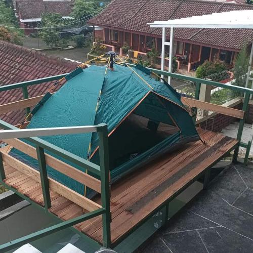 une tente au-dessus d'une terrasse en bois dans l'établissement Vila Dechalasya, à Mojokerto