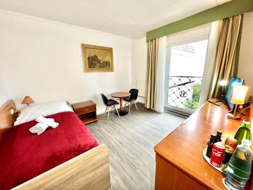 a hotel room with a bed and a table and a window at Schlosshotel Marienbad in Mariánské Lázně