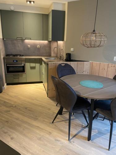 een keuken met een tafel en stoelen in een kamer bij Puur Texels 6 in De Koog