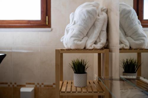 uma pilha de toalhas em duas prateleiras numa casa de banho em Borgomurgia em Andria