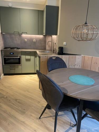 een keuken met een tafel en stoelen in een kamer bij Puur Texels 12 in De Koog