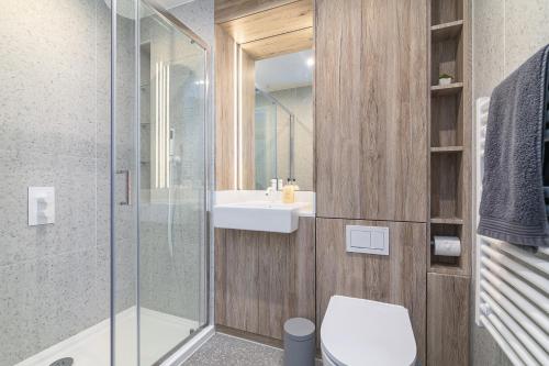 y baño con aseo, lavabo y ducha. en Rooms in Shared Luxury Flat, en Londres