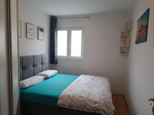 un letto in una camera da letto con finestra di Margareta's Apartment a Kaštela (Castelli)