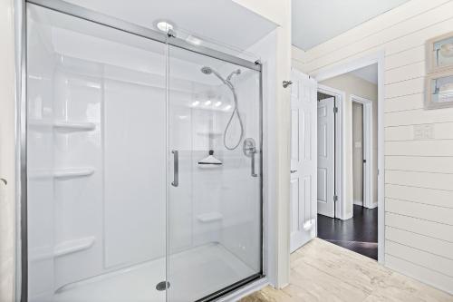 a bathroom with a shower with a glass door at Beachy Keen Cottage in Clearwater Beach