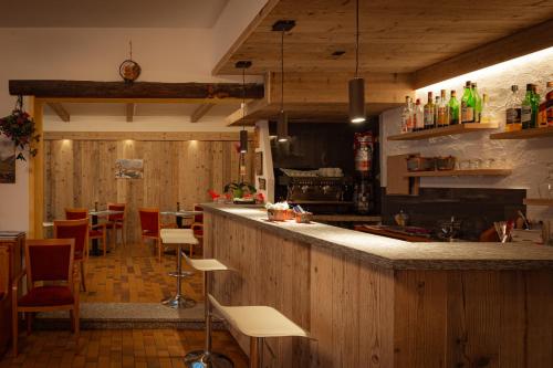 a restaurant with a bar with tables and chairs at Hotel Biancospino in Lanzada