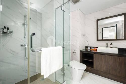 a bathroom with a shower and a toilet and a sink at Carrara by Kozystay 1BR BSD in Samporo