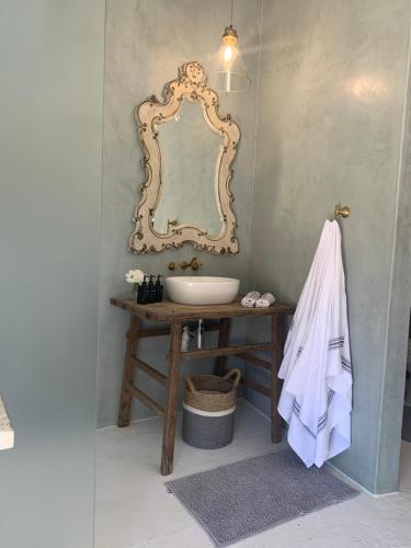 a bathroom with a sink and a mirror on a table at Mount High Luxury Stables in Lydenburg