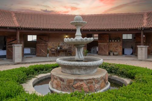 a fountain in the yard of a house at Mount High Luxury Stables in Lydenburg