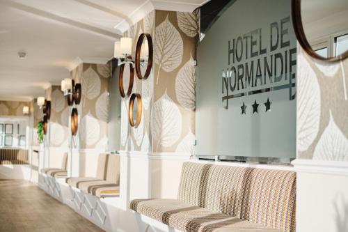 a row of chairs in a waiting room with clocks on the wall at Hotel De Normandie in Saint Helier Jersey