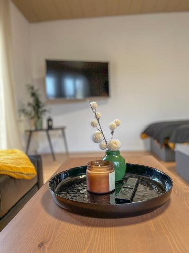 una bandeja con una vela y un jarrón sobre una mesa en Schöne moderne Wohnung Smart Tv, en Waldstetten