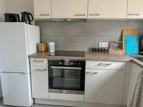 cocina con fogones y nevera blanca en Schöne moderne Wohnung Smart Tv, en Waldstetten