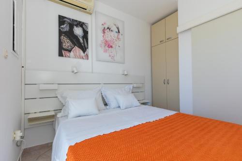 a bedroom with a bed with an orange blanket at Strandhaus Vesna EG 3 in Klek