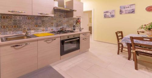 a kitchen with a sink and a stove and a table at Villa Vimani in Paestum