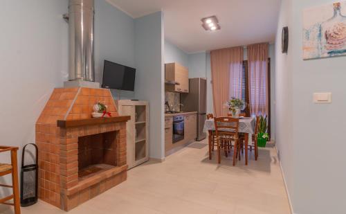 a kitchen and a living room with a brick fireplace at Villa Vimani in Paestum