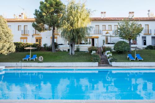 塞特尼的住宿－Hotel Tugasa El Almendral，大楼前设有游泳池的酒店