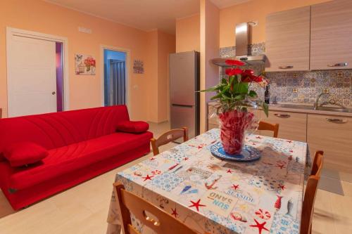 a living room with a table and a red couch at Villa Vimani in Paestum